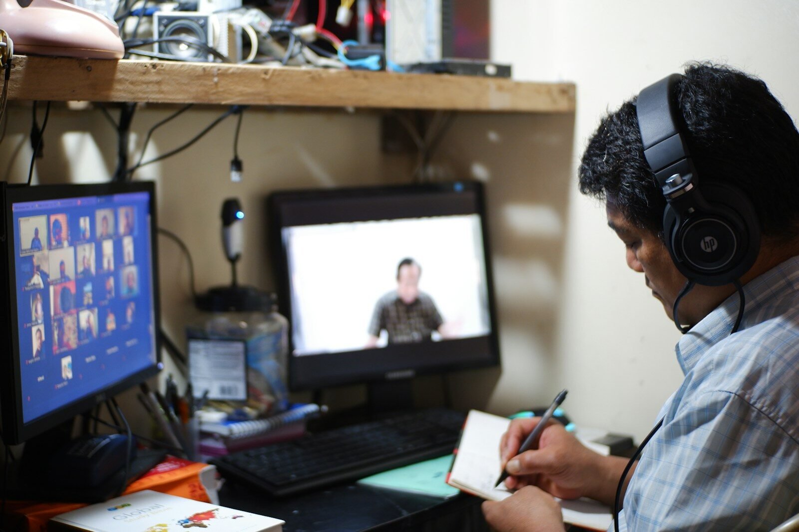 Hombre con camisa de cuadros blancos y negros sosteniendo un papel blanco.